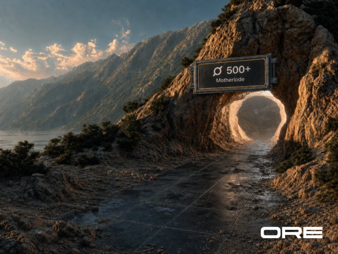 The image shows a sign for a motherlode, which is a type of mine that contains valuable minerals or resources. The sign is located at the bottom center of an image featuring a mountain range with a tunnel leading down into the valley below. The text on the sign reads "500+ Motherlode".
