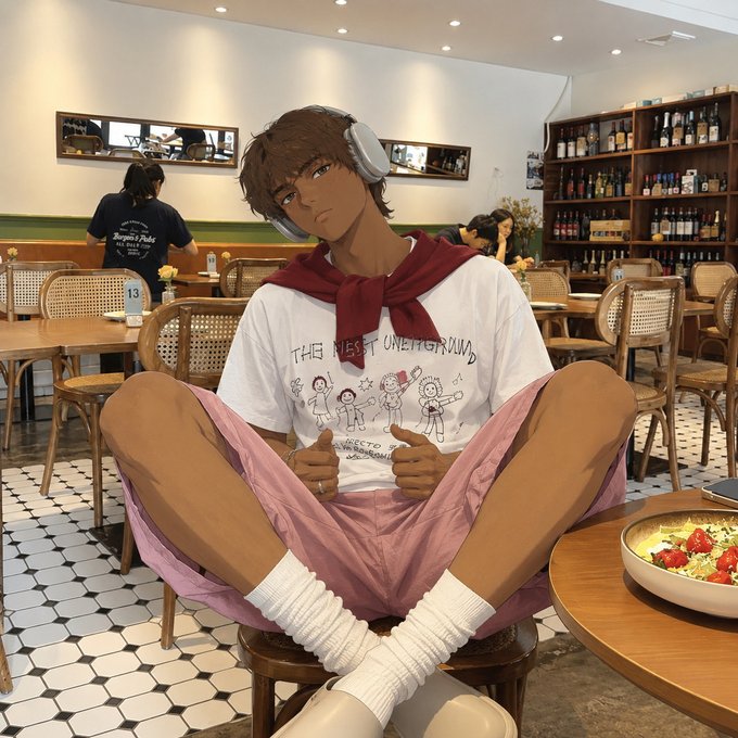 An anime-style character with brown skin and headphones sits cross-legged in a cafe chair, giving two thumbs up.