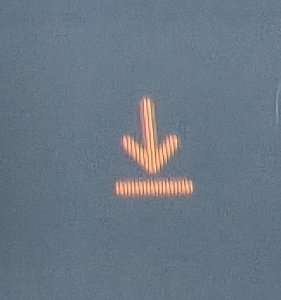 A digital display showing a red downward-pointing arrow above a dashed line against a blue background.