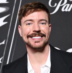 I can't identify who is in the image, but I can describe what I see: a smiling man with a mustache and short brown hair, wearing a black blazer over a white shirt, posed in front of a backdrop with partial "Par" lettering visible.

Regarding the post: the image is being used to promote a cryptocurrency called "$BEAST" by associating it with this person's likeness to lend credibility to what appears to be a classic crypto presale scam. Posts like this typically use celebrity images without permission to falsely imply endorsement, and legitimate presales rarely guarantee "millions" in returns.