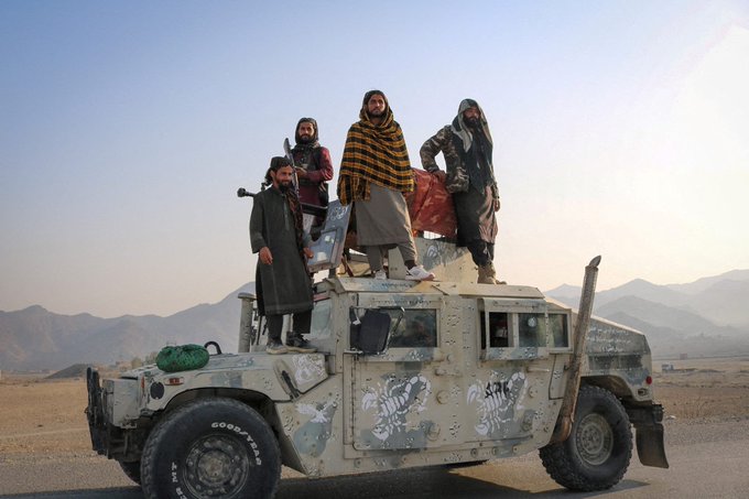 Four armed men stand atop a military Humvee decorated with scorpion graphics in a mountainous desert landscape. The image depicts members of the Taliban, providing a visual target for the accompanying post's claim.