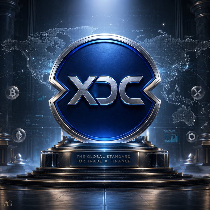 A digital rendering of a large blue and silver 'XDC' coin on a pedestal with the inscription 'THE GLOBAL STANDARD FOR TRADE & FINANCE', set against a world map backdrop with smaller cryptocurrency symbols.