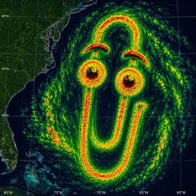 A radar-style satellite image of a powerful hurricane off the U.S. East Coast has been edited to display two googly-eyed spirals forming a smiling face, paired with on-chain trading data humorously attributing Clippy with dominating 83.2% of $MSFT tokenized stock volume ($4,154,840.47 of $4,995,905.82) and 2,559 of 3,991 active traders.