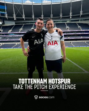 Two friends pose arm-in-arm on the pitch at Tottenham Hotspur Stadium, both wearing Spurs kits featuring the AIA sponsor logo, with text reading "TOTTENHAM HOTSPUR TAKE THE PITCH EXPERIENCE" and "socios.com." The image captures the friendship theme of the post, showing the duo sharing a memorable moment together on the club's field as part of the special stadium experience.