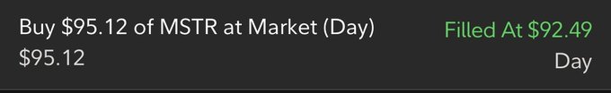 This image shows a trade confirmation for buying $95.12 of MSTR at market, which was filled at $92.49. This relates to the post by showing the specific purchase that contributed to the user's growing MSTR share count.