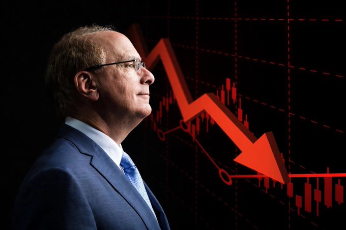 An image of a man in a blue suit and glasses (appearing to be economist Stephen Roach) shown in profile against a backdrop of a red downward-pointing arrow and declining stock chart.