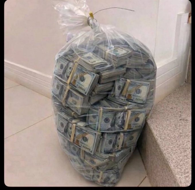 A large clear plastic bag stuffed with banded stacks of US $100 bills sitting on a tiled floor.