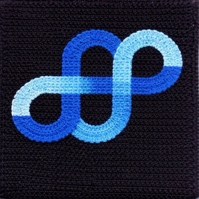An embroidered patch featuring a stylized infinity symbol or interlocking loops stitched in shades of blue and light blue on a black fabric background.