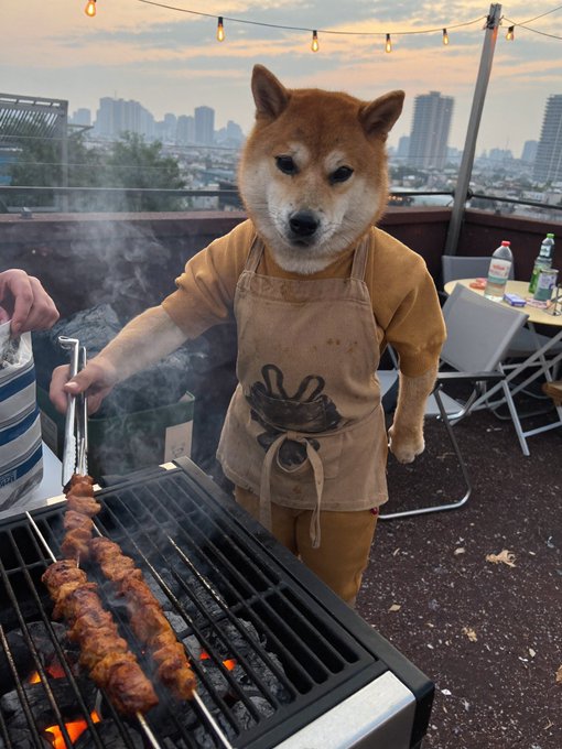 A Shiba Inu dog anthropomorphized with a body wearing a tan apron, standing on a rooftop and grilling skewers of meat over a smoking barbecue.