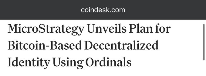 The image shows a CoinDesk headline announcing MicroStrategy's plan to build a Bitcoin-based decentralized identity system using Ordinals, which directly relates to the post's claim that Michael Saylor supports using Ordinals to "spam bitcoin nodes with digital ID information."