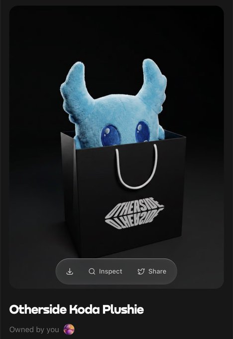 The image features a blue stuffed animal doll sitting inside an open black shopping bag, which has a white handle. The background of the image is dark, making the blue color of the doll stand out even more. There are also some text elements present in the image, including "Otherside Hoda Plushie" and "@apewhale".