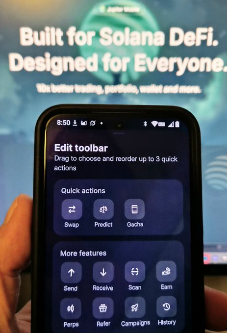 A hand holds a smartphone displaying a crypto app's 'Edit toolbar' menu with quick actions (Swap, Predict, Gacha) and more features (Send, Receive, Scan, Earn, Perps, Refer, Campaigns, History), with text 'Built for Solana DeFi. Designed for Everyone.' visible in the background.