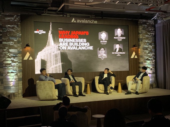 A panel discussion on stage titled 'WHY JAPAN'S LEADING BUSINESSES ARE BUILDING ON AVALANCHE' at an Avalanche event, featuring four speakers seated in armchairs.