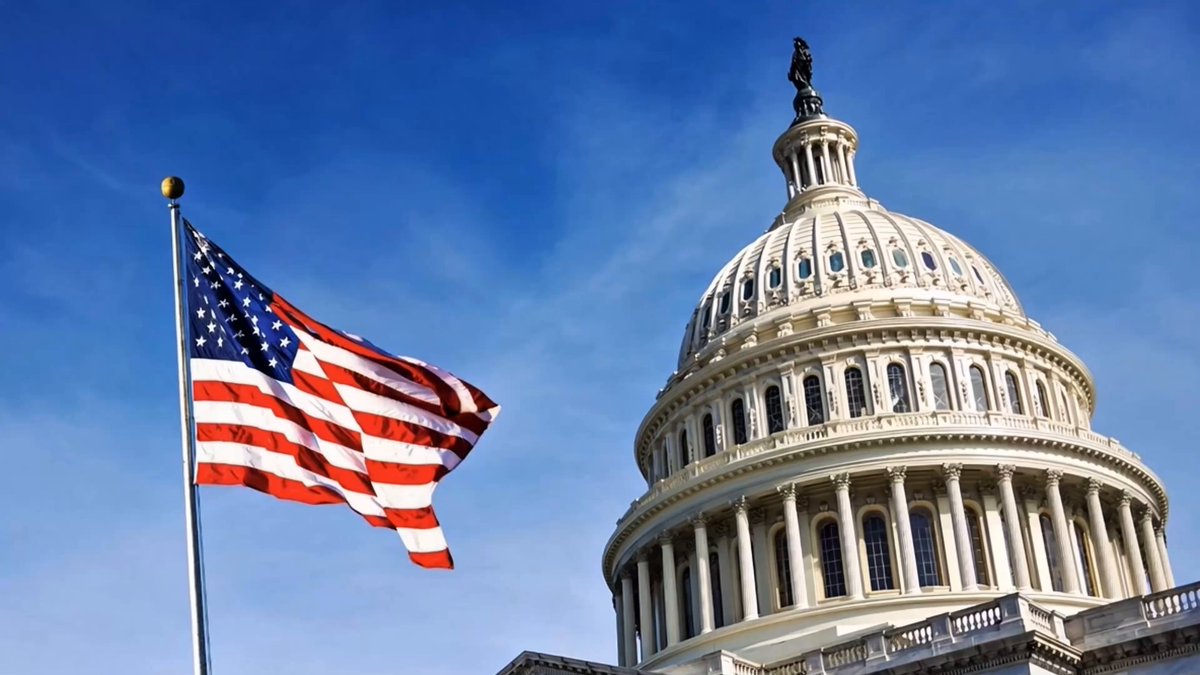 The image features a large American flag flying next to the U.S. Capitol building, which is an iconic landmark in Washington D.C. The caption above the image reads "TODAY IS THE DAY The CLARITY Act reaches the Senate TODAY for markup discussions on crypto regulation". This suggests that there might be ongoing discussions or debates about the clarity of regulations related to cryptocurrencies and digital assets. The focus on these issues is highlighted by the presence of both the flag and the Capitol building in the image, symbolizing the importance of this topic in American politics and society.