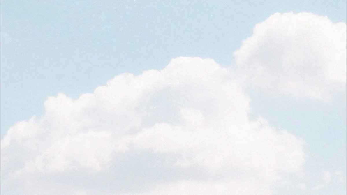 The image features a large white cloud floating in the sky against a gray background. The cloud appears to be floating above an empty space, creating a sense of vastness and tranquility. The image does not contain any text or other objects, making it a simple yet striking visual composition that captures the essence of the cloudy day.