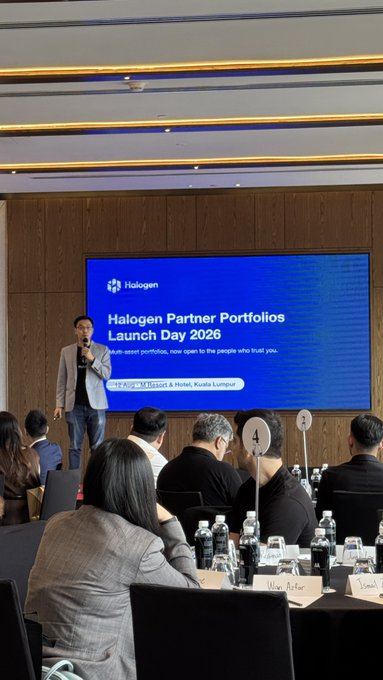 A man presents on stage at the 'Halogen Partner Portfolios Launch Day 2026' event held at Kualie Lumpur Lumpur, addressing a seated audience.