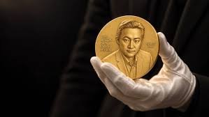 A gold medal bearing the likeness of Justin Sun is carefully held by gloved hands, presented as a prize symbolizing his namesake award that bridges mathematics, formal verification, and AI. The medal visually represents the "#JustinSunPrize" referenced in the post, emphasizing the prestigious nature of the open challenge aimed at advancing AI reasoning.