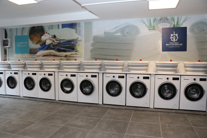 A row of white washing machines lined up in a laundromat with a "Michael Bonsignore" sign and "Rosenthal" branded advertising above them. The image of traditional washing machines serves as a visual metaphor for the "washing" of money through side hustles, contrasting with the post's claim that focusing on Etsy can yield better financial returns than such "nonsense."