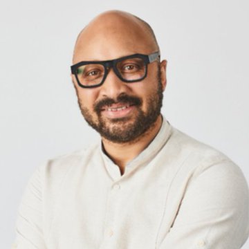 A professional headshot of a smiling, bald man with glasses, a beard, and a cream-colored button-up shirt against a white background. The image appears to be a portrait of a speaker or industry figure, fitting the post's context about Sui ($SUI) blockchain developments, privacy transfer implementation plans, and upcoming events like Sui Basecamp and Token2049.