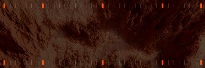 Aerial/satellite view of reddish-brown Mars-like terrain or desert landscape with orange tick markers along the edges.