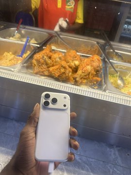 A person holds a smartphone, capturing a photo of a food display case filled with various dishes, including what appears to be fried chicken, noodles, and vegetables. The caption humorously pairs the mundane act of dining out ("touch grass") with an absurdly specific crypto-related instruction ("remove 29.1999 USDT"), blending the worlds of finance and everyday life.