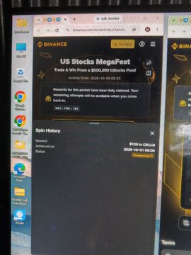 A computer monitor displaying the Binance website with a pop-up celebrating the "US Stocks MegaFest" event and a "Spin History" section showing a reward of $100 in CRC1US.