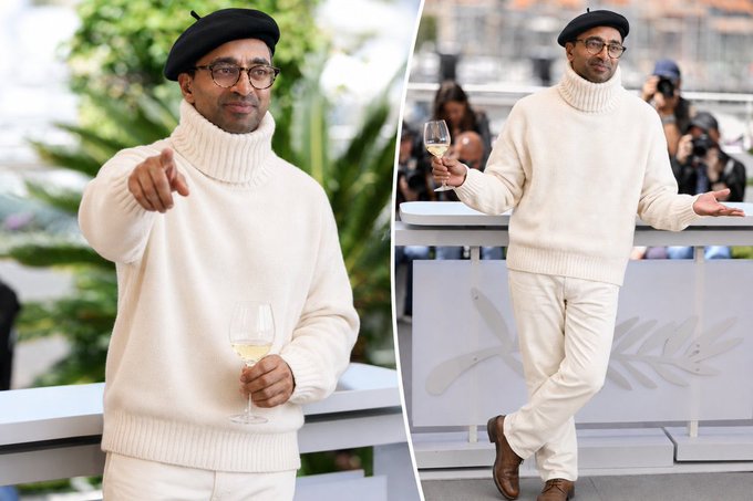 A man wearing a black beret, glasses, cream-colored turtleneck sweater, and cream pants holds a glass of white wine while posing at what appears to be the Cannes Film Festival (with the iconic palm leaf logo visible). The post humorously compares his stylish, relaxed ensemble to the joke about crypto market liquidity, suggesting the man is dressed so well that the usually bland "liquidity" pun feels unexpectedly fashionable.