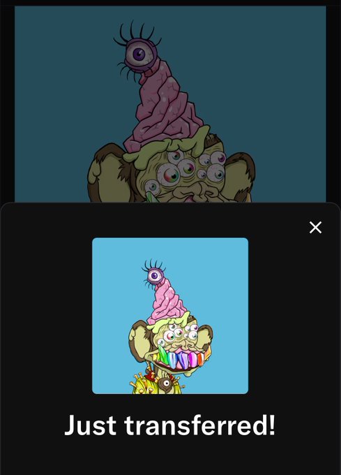 A mobile app screen displaying a cartoon creature with multiple eyes and a pink swirled hat, with a popup notification at the bottom reading 'Just transferred!'