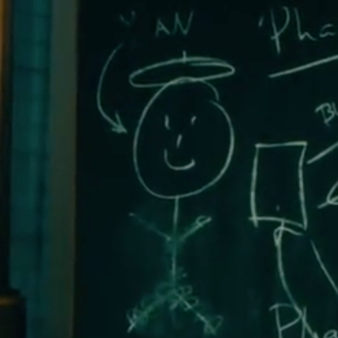 A chalkboard displays a childlike chalk drawing of a stick figure with a smiling face and a halo, labeled "YAN" with an arrow pointing to it, alongside partial text including "Pha" and other faint chalk sketches.