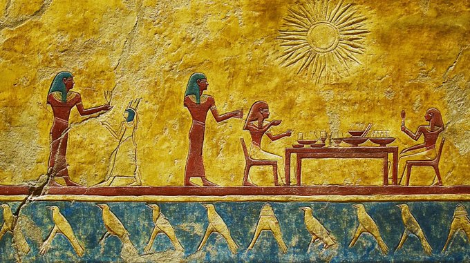 An ancient Egyptian wall painting or relief depicting figures in traditional attire, with a sun symbol at the top and hieroglyphic-style figures along the bottom border.