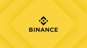 The image features a yellow diamond-shaped logo with the word "Binance" written inside of it. The logo is positioned centrally within the frame, drawing attention to its message. The background of the image is black, which contrasts with the yellow diamond shape and makes the text stand out even more. This design choice emphasizes the importance of the "Binance" brand name in a visually striking manner.