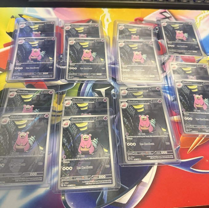 Multiple stacks of identical Slowbro Pokémon trading cards displayed in plastic sleeves, arranged on a colorful mat.