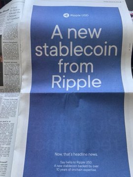 A newspaper advertisement with bold blue typography reading "A new stablecoin from Ripple" promotes Ripple USD (RLUSD) as "a new stablecoin backed by over 10 years of on-chain expertise," tying directly into the post's announcement of RLUSD's explosive growth and rising institutional adoption.