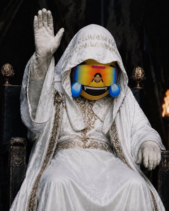 A figure in elaborate white and gold robes sits on an ornate throne with one hand raised, but has a crying laughing emoji superimposed over their face.