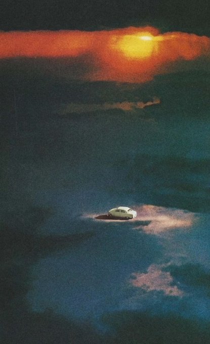 Surreal painting showing a small yellow car driving through dark clouds beneath a glowing red-orange moonlit sky.