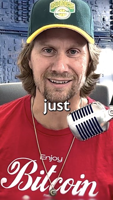 The image shows a man wearing a Sonics cap and a red "Enjoy Bitcoin" t-shirt speaking into a vintage-style microphone, with the word "just" displayed across the image. The Bitcoin-themed attire aligns with the post's emphatic "IT'S TRUE!" declaration, suggesting an enthusiastic endorsement of Bitcoin.