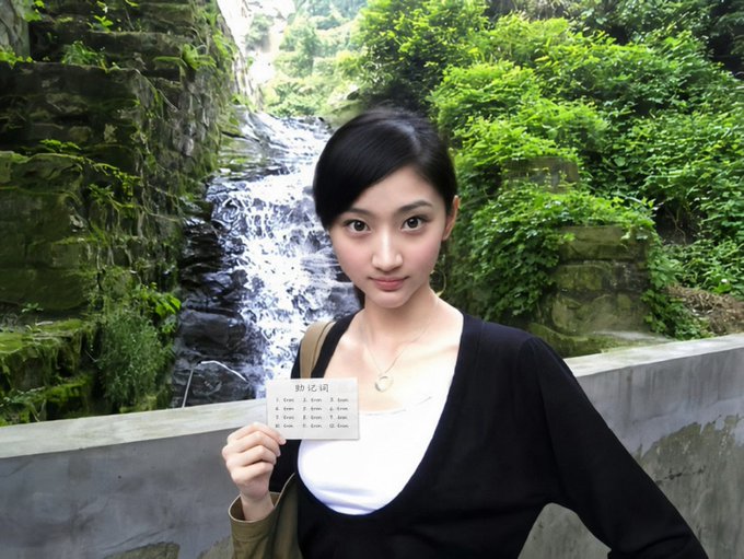 A young woman poses in front of a waterfall, holding a small card that reads "助记词" (mnemonic phrase) with numbered items listing what appears to be cryptocurrency wallet recovery words, humorously illustrating the post's joke about Jing Tian's naive trust in receiving crypto without knowing how to secure a wallet.