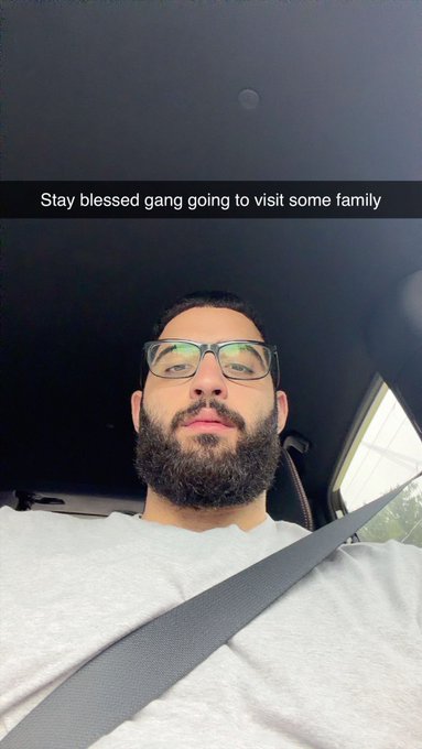 A selfie of a bearded man wearing glasses in a car with the Snapchat caption 'Stay blessed gang going to visit some family'.