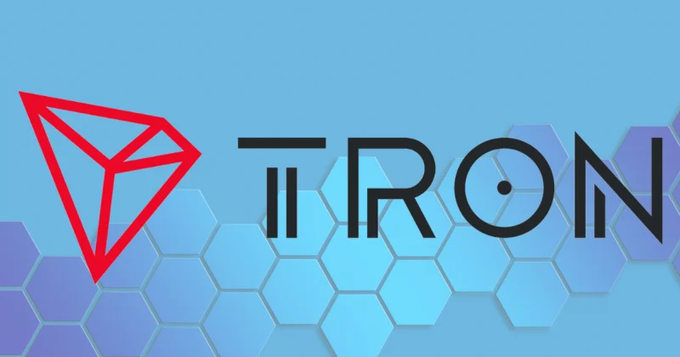 The TRON cryptocurrency logo, featuring a red geometric diamond shape and black stylized text, set against a blue hexagonal pattern background.