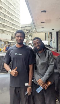 Two men pose together on a city street; one wears a "LINGO" t-shirt while holding a phone, fitting the post celebrating two notable builders met at the event.