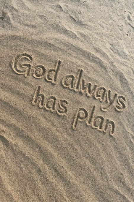Text written in sand that reads 'God always has Plan'.