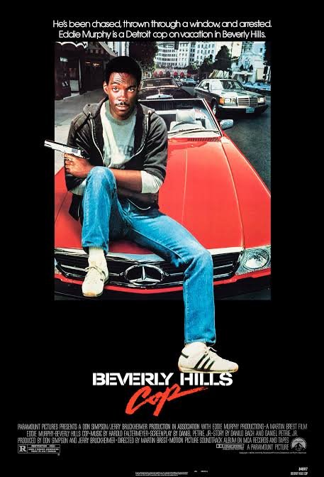 The iconic movie poster for 'Beverly Hills Cop' featuring Eddie Murphy sitting on the hood of a red Mercedes-Benz convertible, holding a gun, with the tagline about being thrown through a window and arrested.
