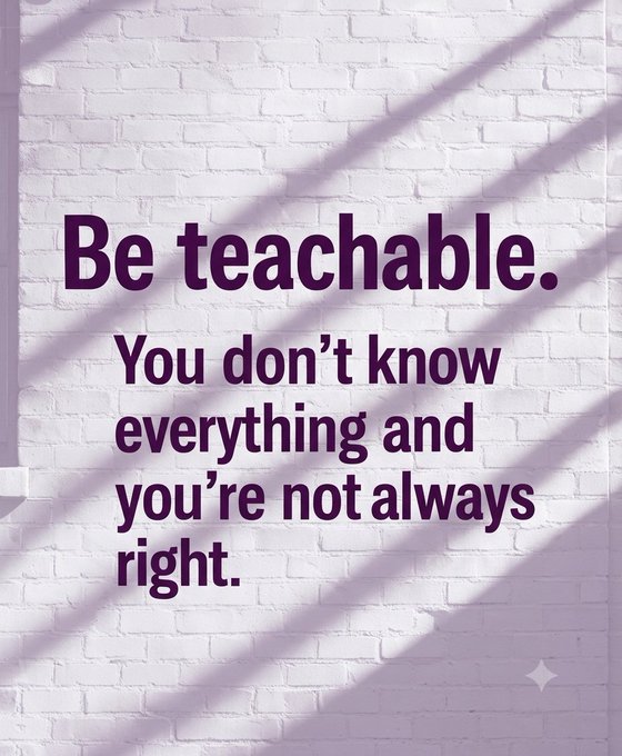A motivational poster with purple text on a white brick wall reads 'Be teachable. You don't know everything and you're not always right.'