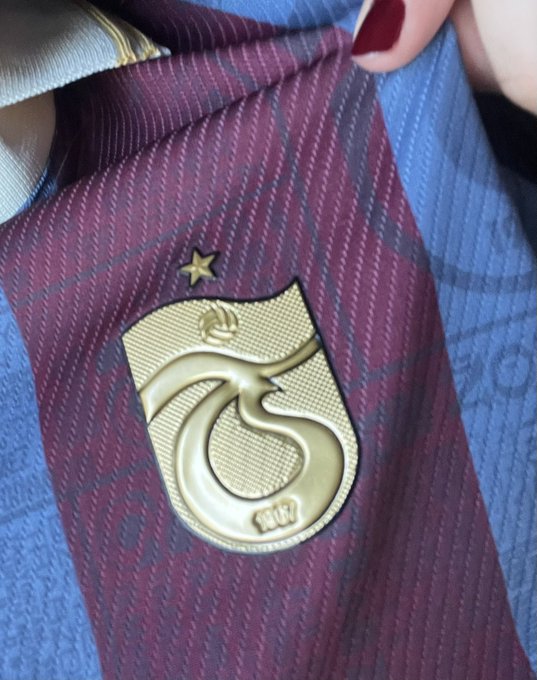 A gold "Owl City" pin featuring a stylized eagle and star rests on a maroon and navy striped tie, the band's "Ocean Eyes" eagle logo giving off an edgy, military-style aesthetic that matches the post's "terrorist-fucking vibe" comment.