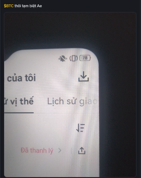 A photo of a phone screen showing Vietnamese text including 'Lịch sử giao dịch' and 'Đã thanh lý', with a caption reading '$BTC thôi tạm biệt Ae'.