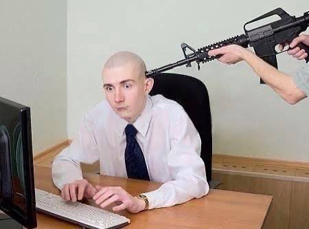 A bald man in a dress shirt and tie sits calmly at a computer while another person behind him points what appears to be an assault rifle at his head—visually representing the "pump.fun holding a gun to my head" metaphor, where outside pressure forces traders to chase trendy toppers instead of investing in quality meme coins like $ANSEM.