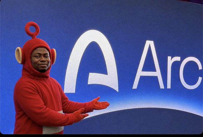 A man in a red Teletubby costume gestures toward a large blue screen displaying the Arc browser logo.