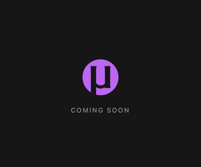 A minimalist 'Coming Soon' announcement featuring a purple circular logo with a stylized letter on a black background.
