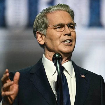 Treasury Secretary Scott Bessent, a gray-haired man in a dark suit, speaks passionately at a podium into a microphone, gesturing with his hand. The image accompanies news of his endorsement of the CLARITY Act, emphasizing its importance in advancing U.S. leadership in global technology competition.
