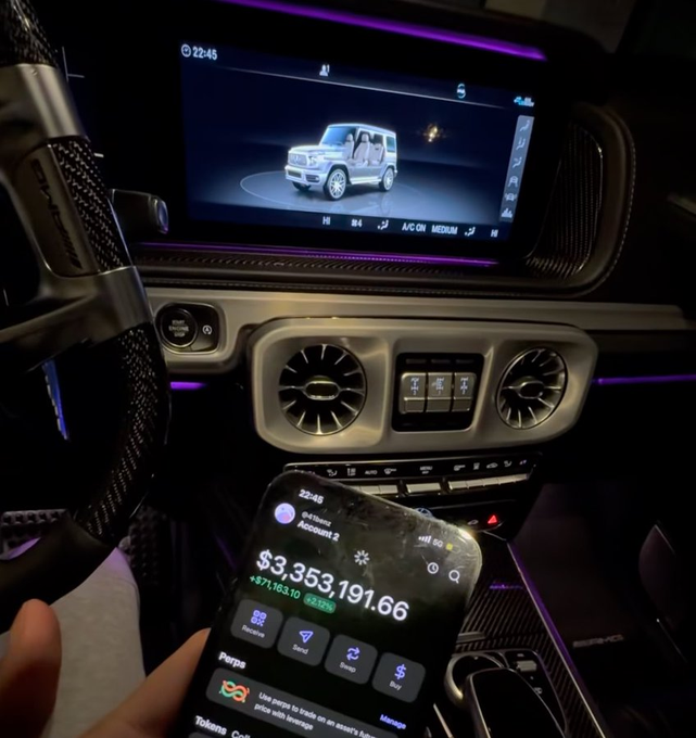 A hand holds a phone displaying a crypto wallet balance of $3,353,191.66 in Account 2, up $871,163.10 (+32.43%), set against the backdrop of a luxury vehicle's dashboard featuring ambient purple lighting. The image captures the moment of celebrating substantial crypto gains while behind the wheel, fitting the caption's anticipation of wealth and success arriving.
